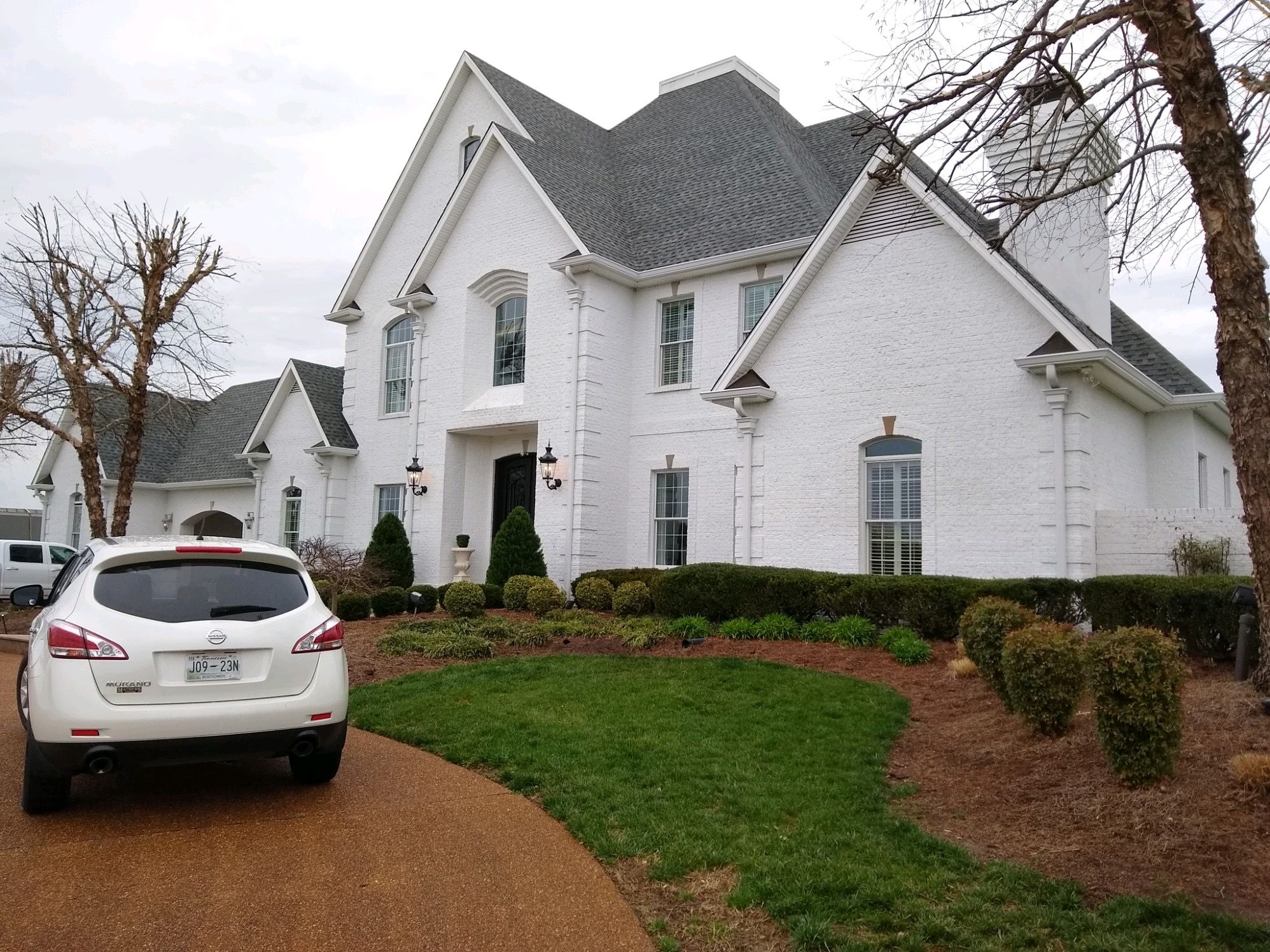 Elegant white brick home featuring premium new roof installed in Clarksville, TN.
