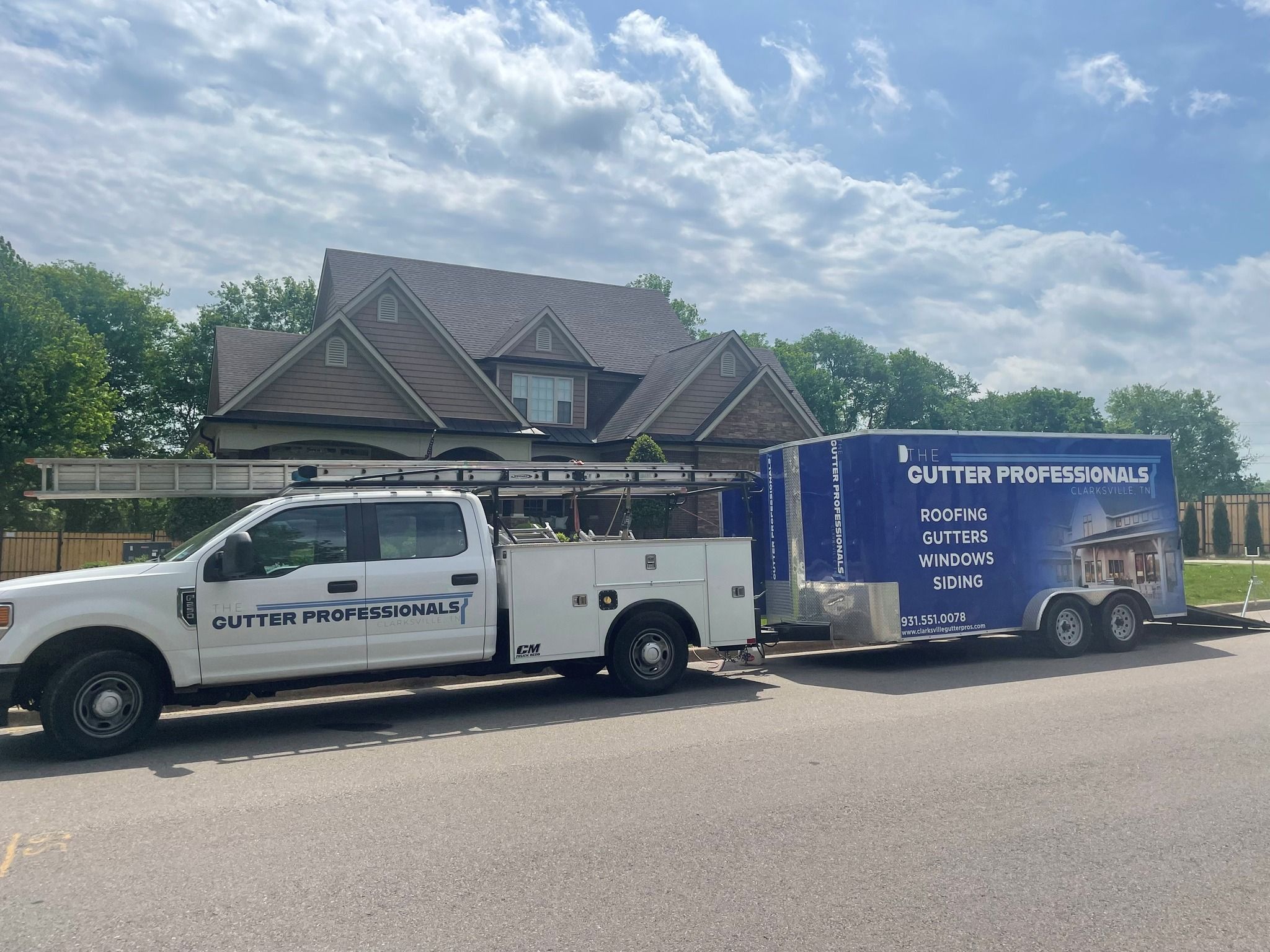 Clarksville roofing professionals on site with truck and trailer for gutter and roofing services.